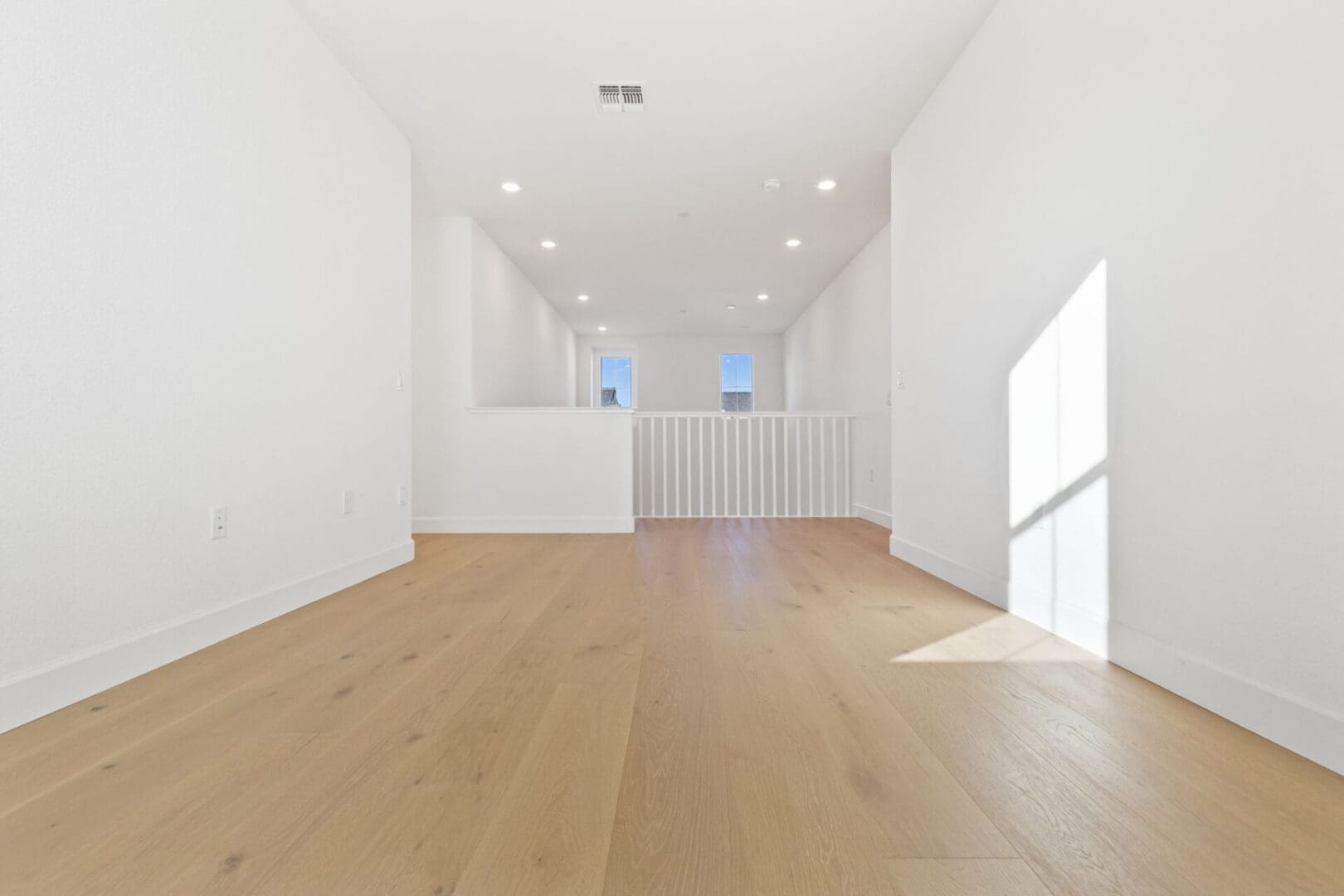 Empty room with wooden floor and white walls.