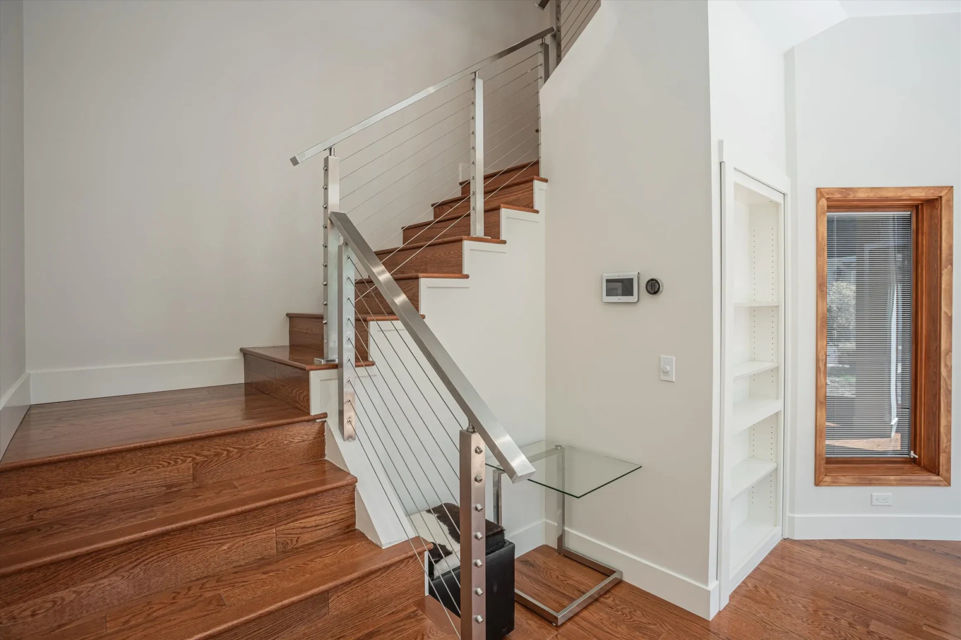 Modern wooden staircase with metal railing.